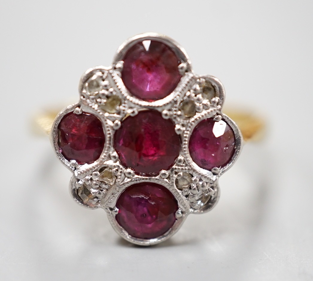 A 1920's 18ct and plat and five stone ruby set quatrefoil shaped ring, with diamond chip spacers, size L, gross weight 3.5 grams.
